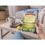 Book titled 'SNIP HAPPENS' held by a person with a coffee cup and glasses on a table in the background.